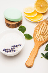 Fototapeta na wymiar bowl with lavender, sliced lemon, brush, and soap on blurred white 