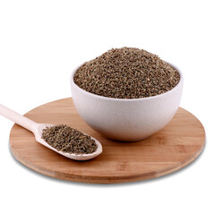 Pile of dried anise spice in white ceramic bowl on wood board isolated on white background, copy space.