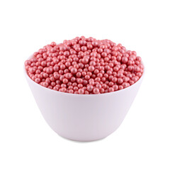 Pink sugar dragee in white bowl isolated on white background, copy space.