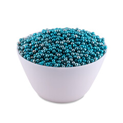 Blue sugar dragee in white bowl isolated on white background, copy space.