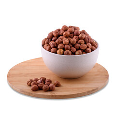 Peeled roasted hazelnuts in white bowl on wood board isolated on white background; copy space.