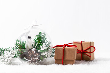Beautiful Christmas composition with handmade decorative ball and graft gift boxes on white background with copy space for your text. Christmas and New Year greeting card template.