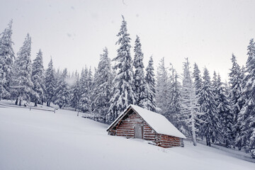 Fantastic winter landscape with wooden house in snowy mountains. Christmas holiday concept. Carpathians mountain, Ukraine, Europe