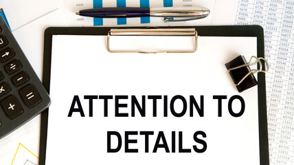 Fototapeta premium On the tablet for writing the text ATTENTION TO DETAILS, next to the calculator, pen, charts, reports.