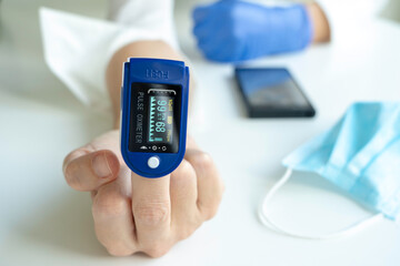 Woman using pulse oximeter to show by hand the symbol of the fuck off. Coronavirus concept.