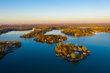 Szigetszentmiklós, Hungary - Aerial drone view of a tiny fishing island on Lake Kavicsos (Kavicsos to) near Budapest. The island is full with fishing huts, piers and cabins. Warm autumn colors.