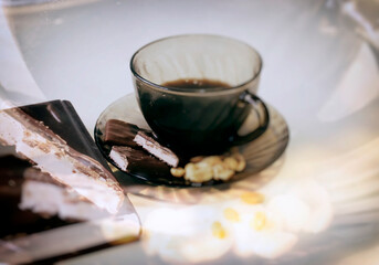A cup of coffee with nuts and chocolate  in the glare of light 