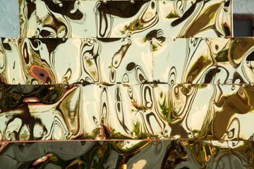 Metallic gold color, shiny reflective textured background..