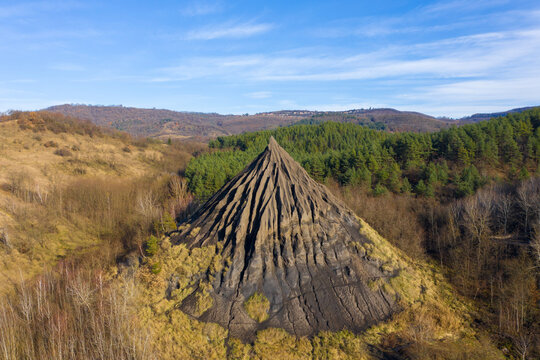 Salg&oacute;tarj&aacute;n, Hungary - Aerial view of abandoned slag heap covered by grass against blue sky, autumn landscape