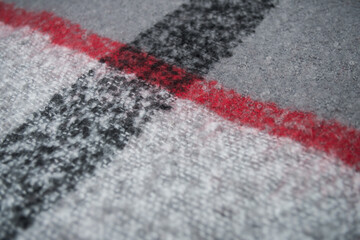 Closeup of red, black and grey woolen scarf texture
