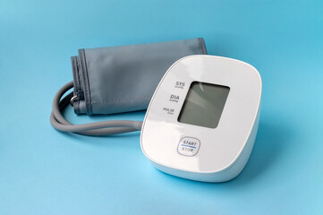 Automatic blood pressure monitor on blue background. Medical electronic tonometer