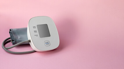 Automatic blood pressure monitor on pink background. Medical electronic tonometer. Banner, template...