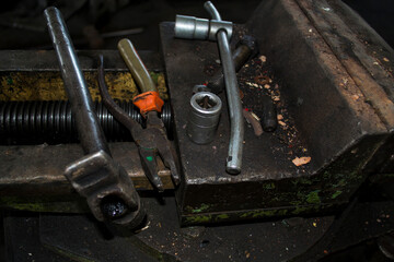 Keys, plaskagubtsi, a hammer are in a vice. The working tool is in fuel oil.