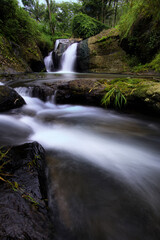 Obraz premium Paradise waterfall in a green forest. Beautiful waterfall in a forest, landscape mode waterfall view.