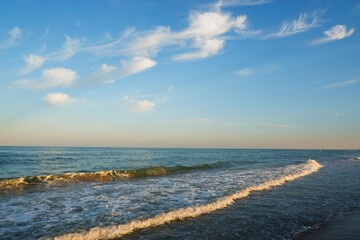 Sea beach with blue sky and yellow sand and some clouds