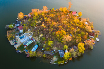 Szigetszentmiklós, Hungary - Aerial drone view of a tiny fishing island on Lake Kavicsos (Kavicsos to) near Budapest. The island is full with fishing huts, piers and cabins. Warm autumn colors.