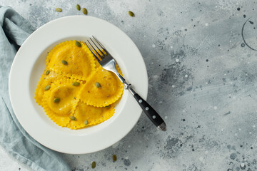 Homemade Pumpkin Ravioli with butter on a light concrete background. Top view with copy space