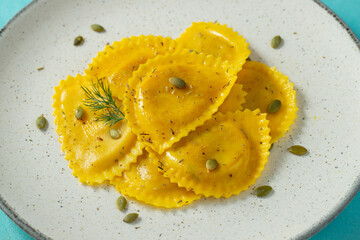 Homemade Pumpkin Ravioli with butter on a light concrete background. Top view