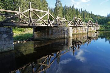 Fototapeta premium Historic canal bridge across river used for transport timber, Modrava, Sumava National Park, Czech Republic