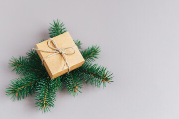 Craft gift box with spruce branch on a grey background. Holiday eco-friendly concept.