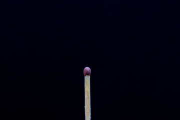 Single matchstick isolated on black background