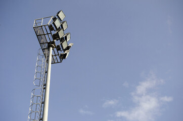 Spotlight pole in stadium and blue sky back ground.