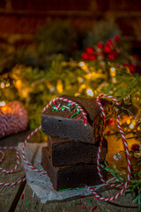 Christmas brownie cake pieces, dark chocolate sweet dessert on wooden background with Xmas decoration,