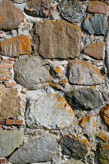 A wall of cut stone. Granite. Dough. Surface.