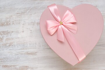 Valentine's day holiday.Pink heart box with bow ,with white card on a light shabby chic background. Blank postcard.Love  concept.Valentine's Day gift.copy space