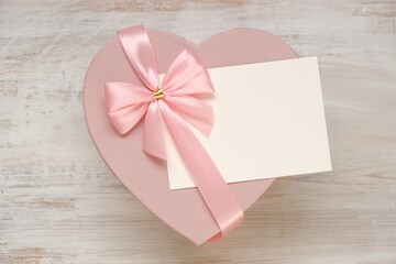 Valentine's day holiday.Pink heart box with bow ,with white card on a light shabby chic background. Blank postcard.Love and passion concept.Valentine's Day gift.copy space