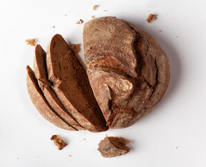 Freshly baked brown bread on white background. Flat lay.