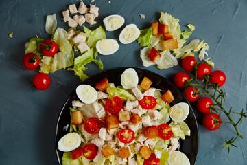 Caesar salad with the ingredients. Flat lay. On dark background.