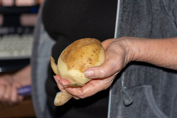 Unpeeled potatoes in hand