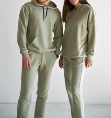 couple standing together in mono colored sportswear. man and woman wears light green clothes