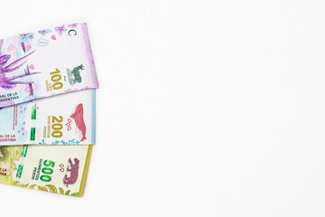 100, 200, 500 argentine pesos cash money appear from the left side of the frame above white background