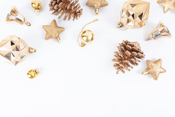 Top view of golden and yellow Christmas elements , pine cone, gold ball, stars glitter, gold ball, bells on white background with copy space.