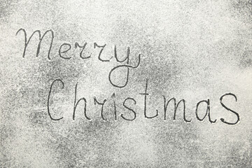 Christmas composition. Merry christmas text made with flour on black background.