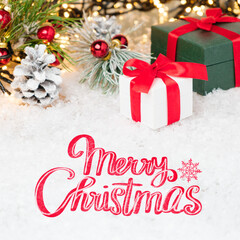 Merry Christmas greeting card with gift boxes and red ribbon on the snow.