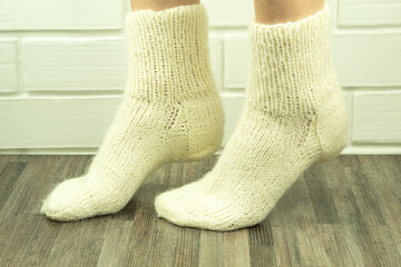 Handmade socks from white threads, crocheted socks close-up
