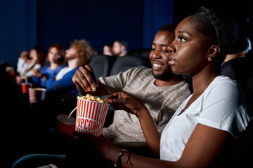 African couple enjoying date in cinema.