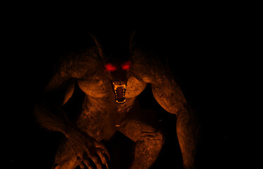 3d illustration of a glowing eyed Werewolf/Dogman illuminated by firelight