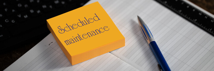 Close-up of a memory stick with the word scheduled maintenance.