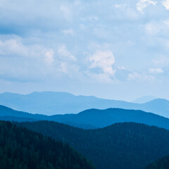 Obraz premium Beautiful landscape of blue mountains layers with clouds