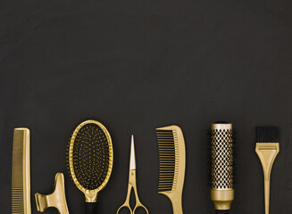 Hairdressing tools in gold on a dark gray background with space for text on top. Hairdressing...