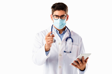 Studio shot of male doctor wearing face mask while pointing his finger to you