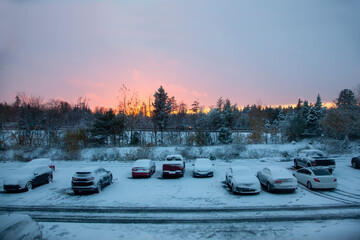 home in winter parking lot with sunset