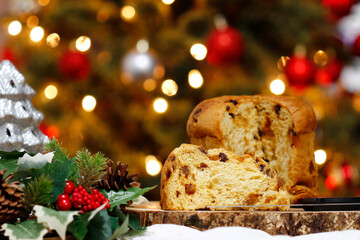 Panettone on a board with Merry Christmas tree, lights, pine cone and a candle