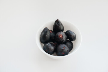 Ripe and sweet figs cut and arranged in a plate on a white background with free space. Fruits and vegetarianism