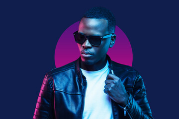 Neon portrait of african american man, wearing sunglasses and leather jacket, isolated on blue...