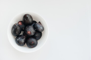 Ripe and sweet figs cut and arranged in a plate on a white background with free space. Fruits and vegetarianism